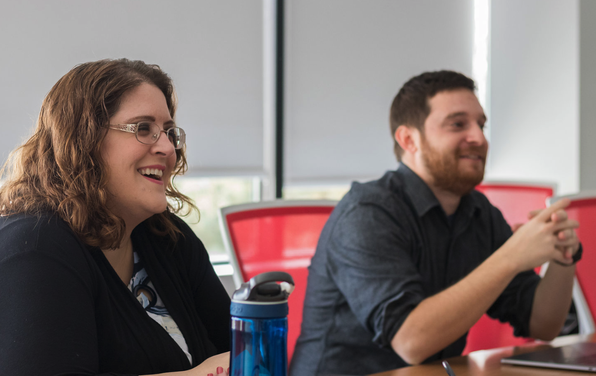 Two coworkers laughing in meeting