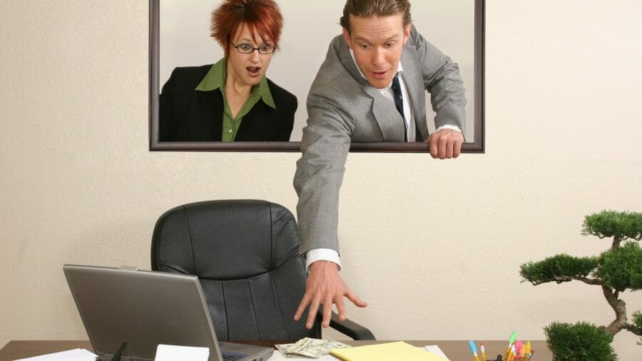 Two people reaching towards desk