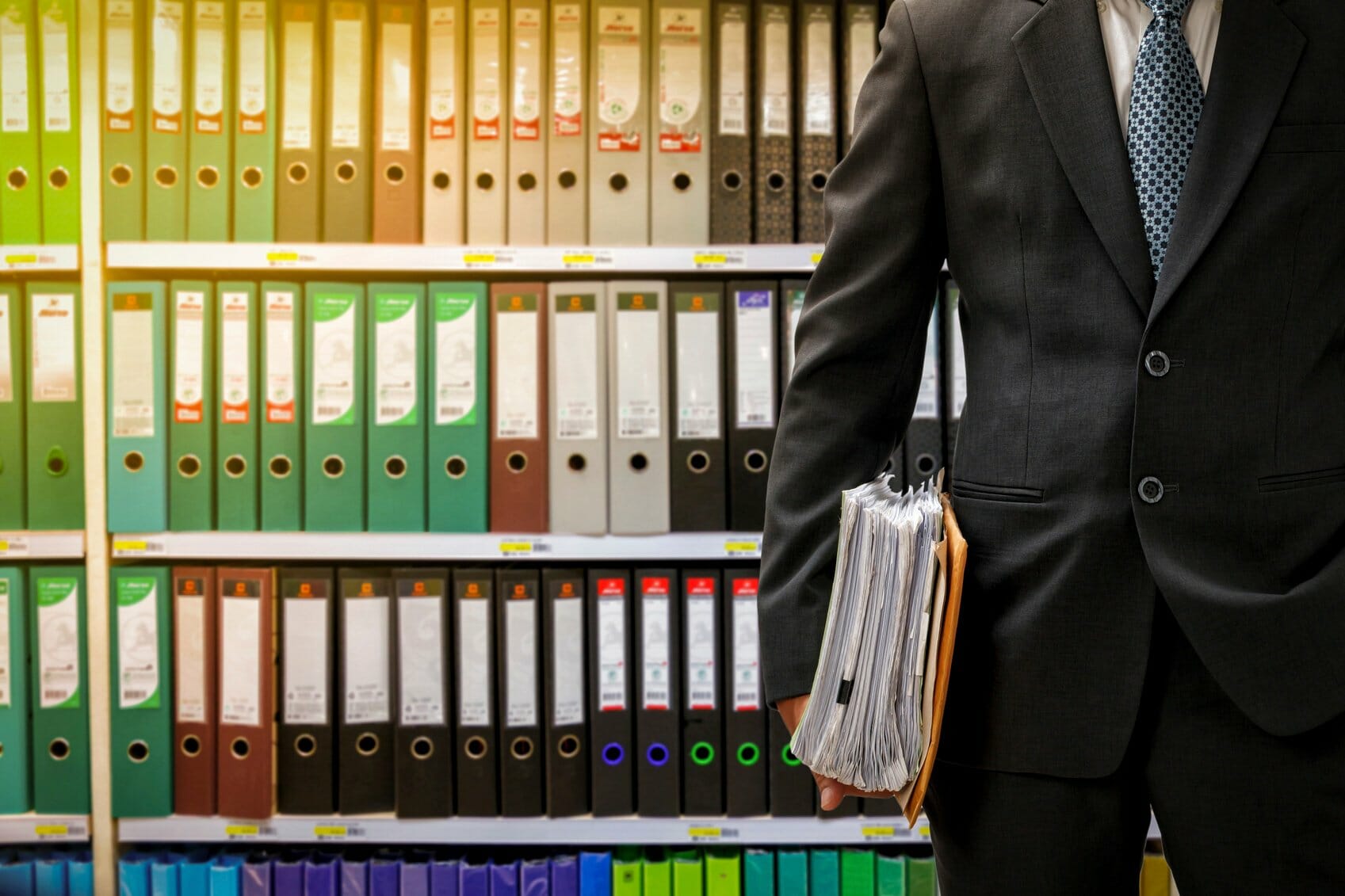 Business man in front of binders