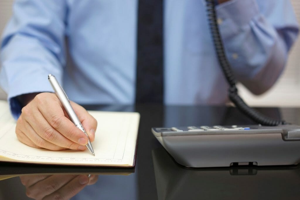 Man on phone taking notes