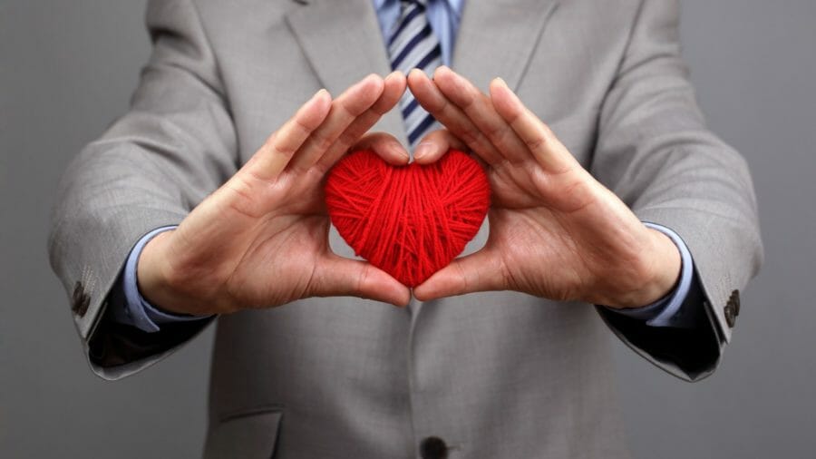 Man holding ball of yarn shaped as a heart