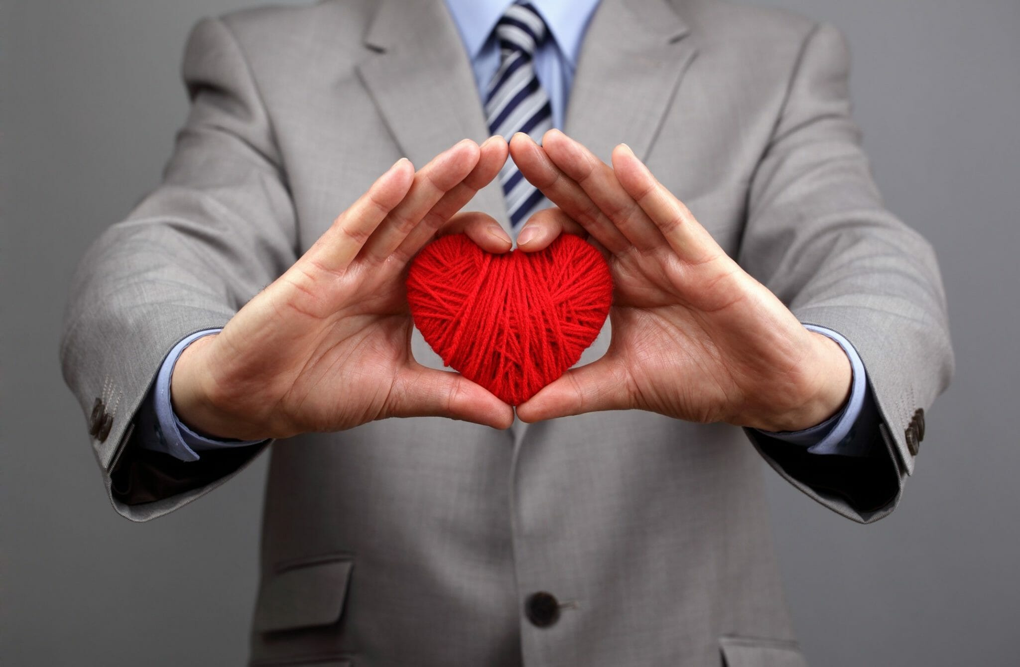 Man holding ball of yarn shaped as a heart