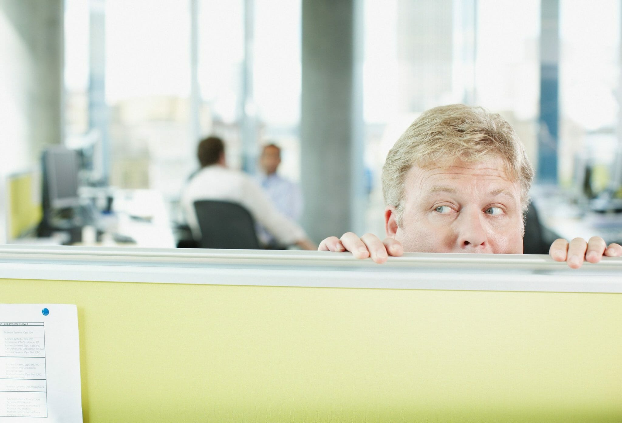 Man peering over desk