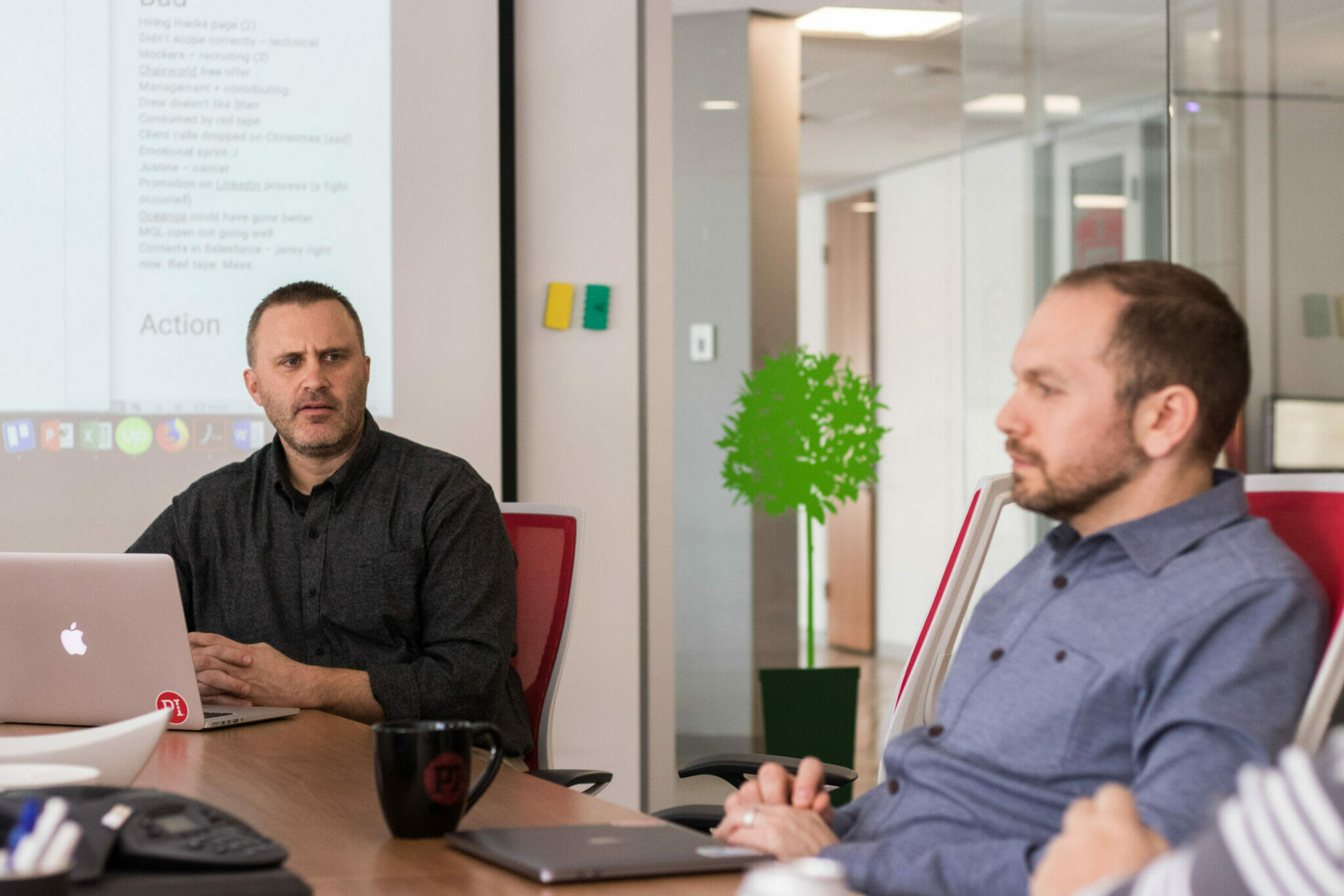 Two managers sit in a meeting room at an office