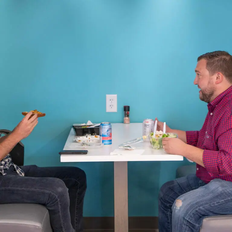 two employees talking and eating