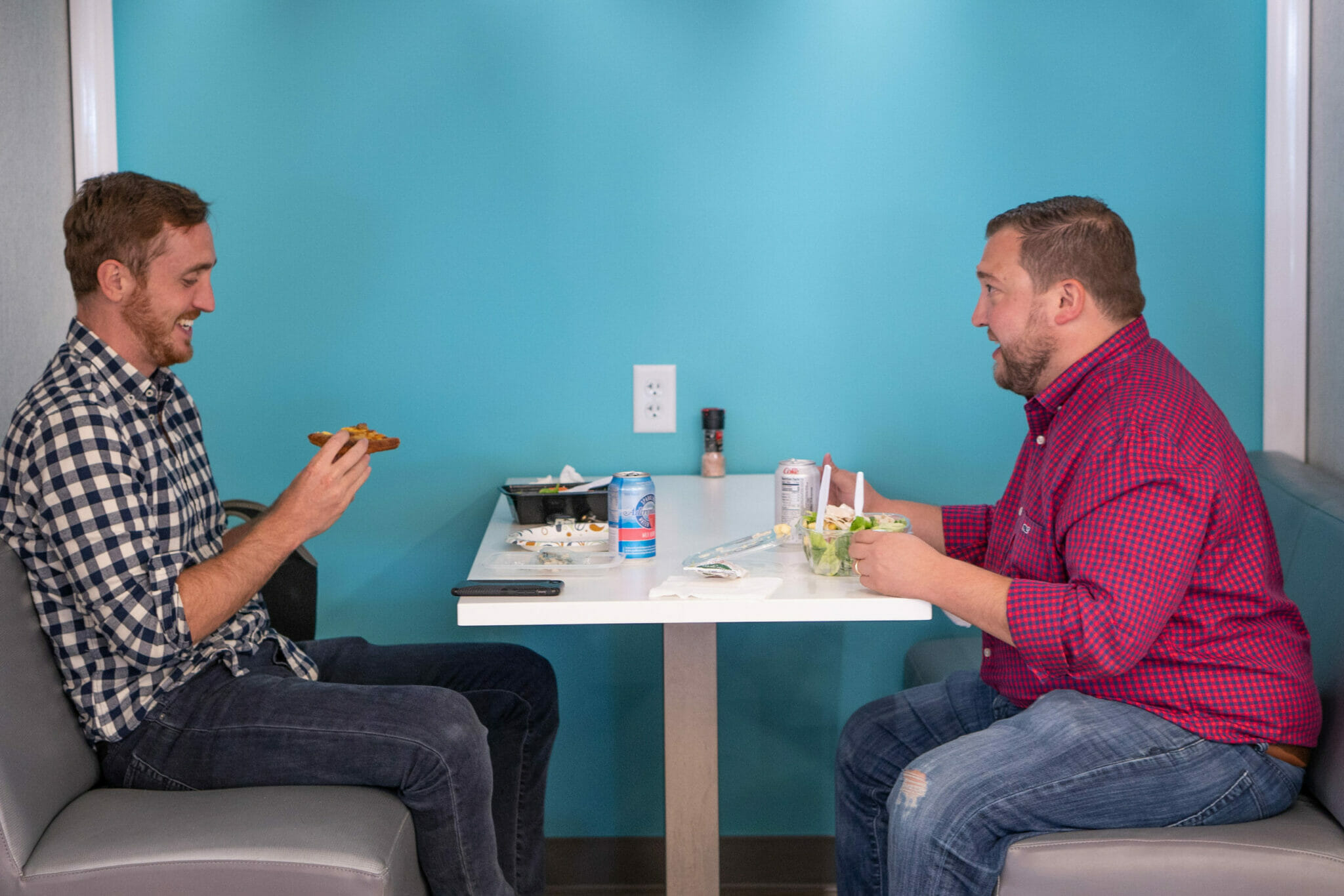 two employees talking and eating