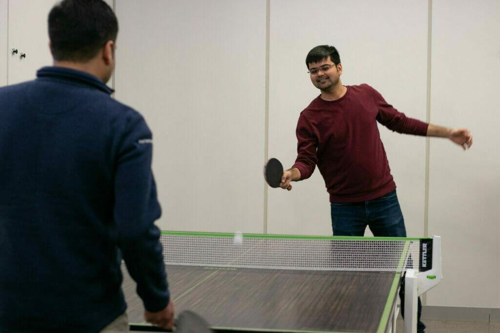 Employees playing ping pong in the office